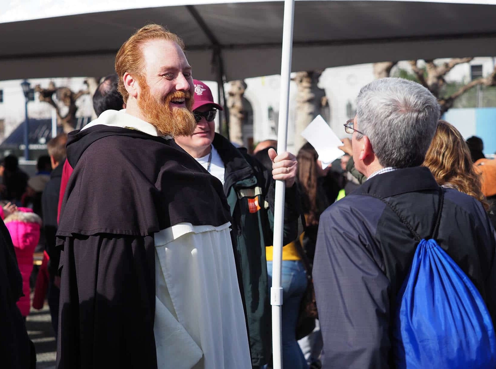 Fr. Michael Hurley, O.P. smiles while speaking with a man at a public event.
