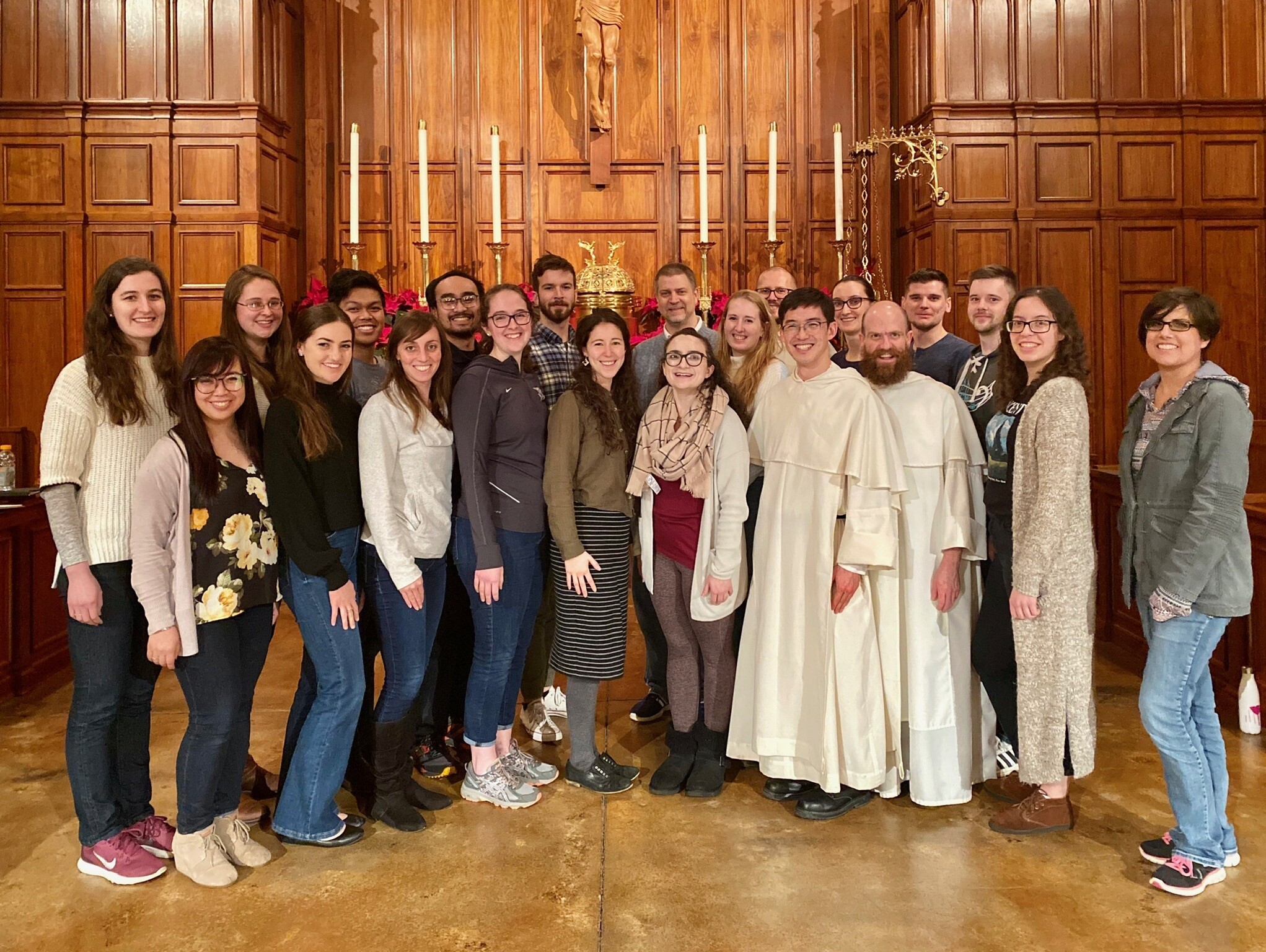 Friars pose in a group photo with young adults in the sanctuary of Blessed Sacrament Parish, Seattle.